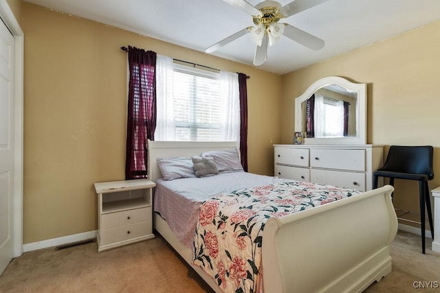 bedroom featuring ceiling fan, multiple windows, and light carpet