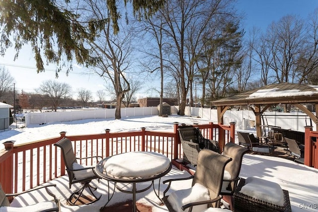 snow covered deck featuring a shed