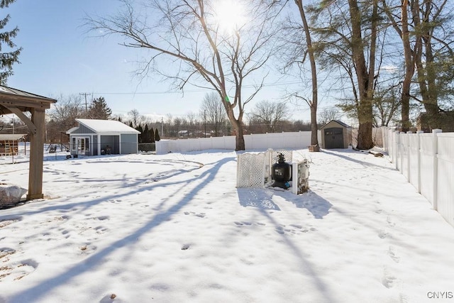 snowy yard featuring a shed