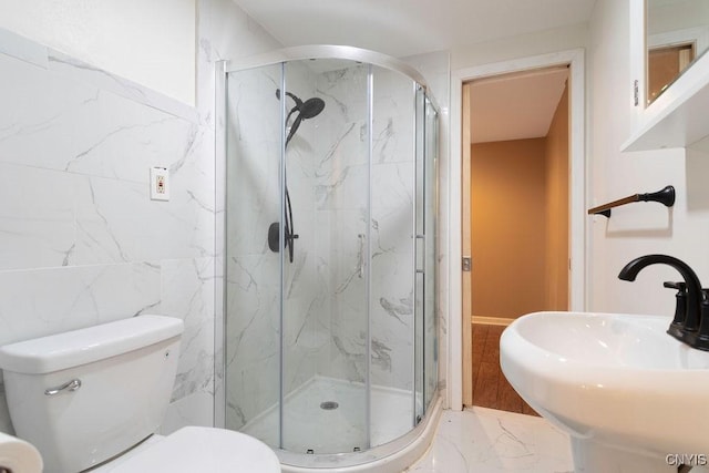 bathroom featuring a shower with shower door, sink, tile walls, and toilet