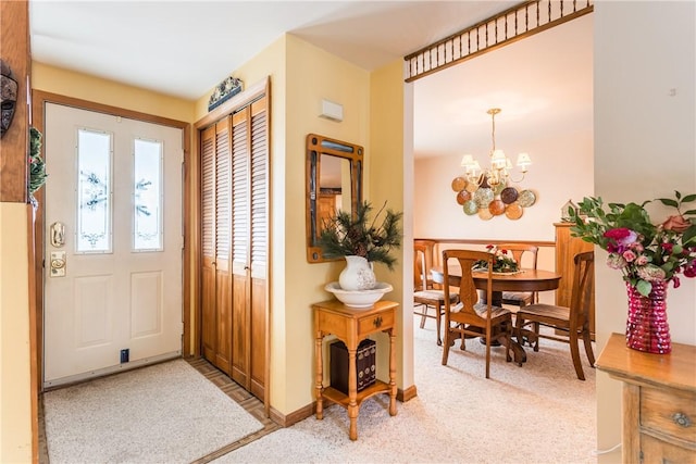 entrance foyer featuring light colored carpet and a notable chandelier