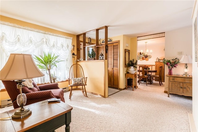 sitting room with a notable chandelier, baseboard heating, and light carpet