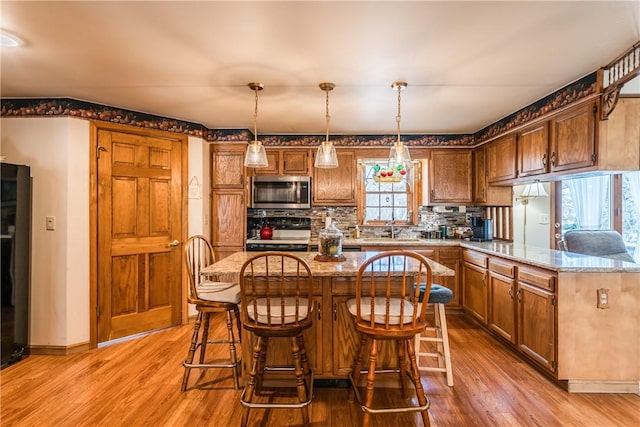 kitchen featuring sink, hardwood / wood-style floors, a healthy amount of sunlight, and pendant lighting