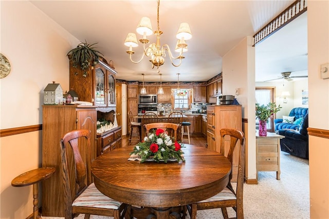 dining room with light carpet and ceiling fan with notable chandelier