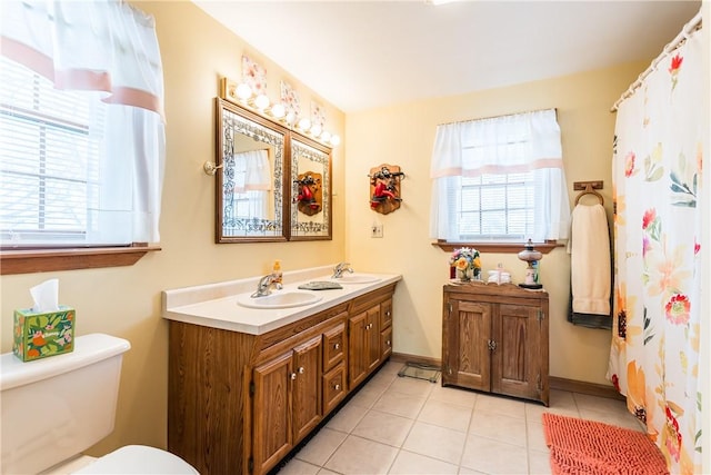 bathroom featuring vanity, toilet, a wealth of natural light, and tile patterned flooring