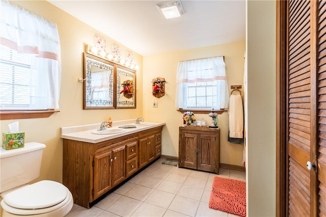 bathroom with vanity, toilet, a healthy amount of sunlight, and tile patterned floors