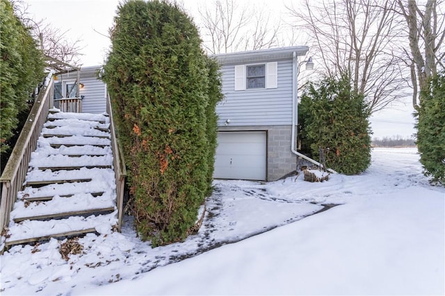 view of snow covered exterior with a garage