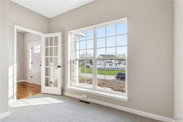 entryway with light carpet and plenty of natural light