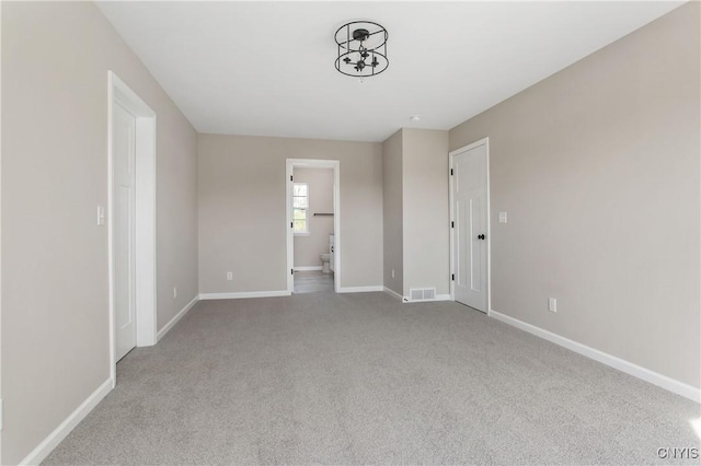 unfurnished bedroom with light colored carpet and connected bathroom