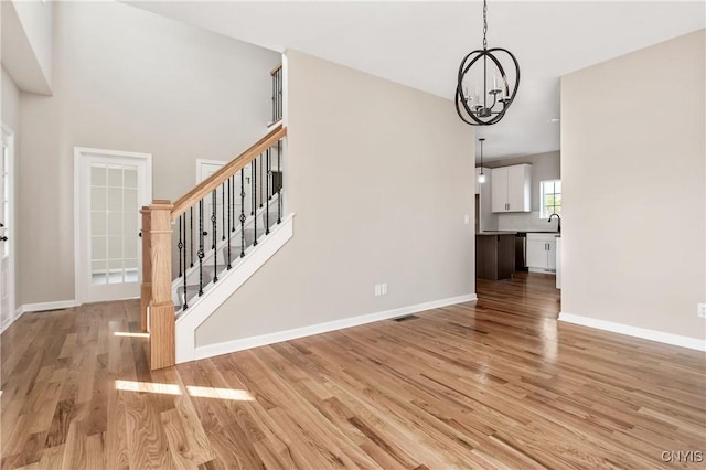 interior space with sink, a notable chandelier, and light wood-type flooring