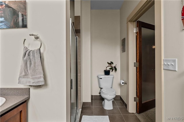 bathroom with a shower with door, toilet, tile patterned flooring, and vanity