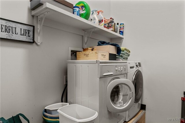 clothes washing area with washing machine and dryer