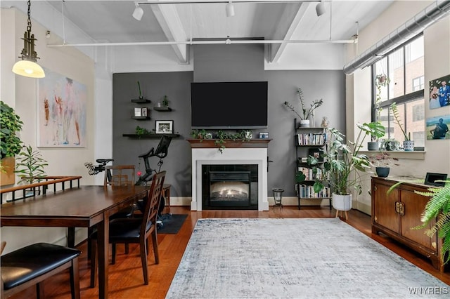 living room with a fireplace with flush hearth, wood finished floors, and baseboards