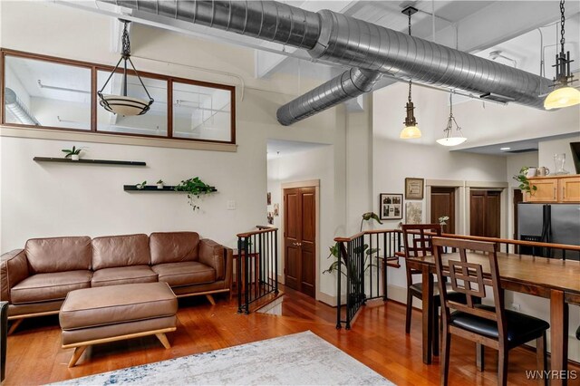 living room with a towering ceiling and wood-type flooring