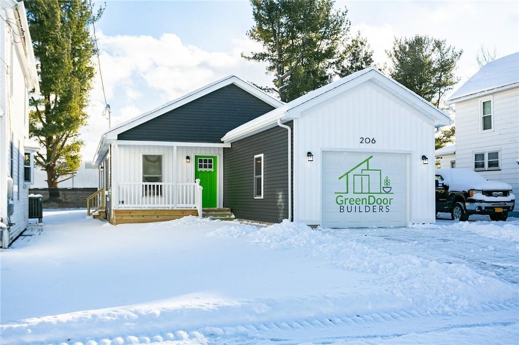 view of front of home with a garage and central air condition unit