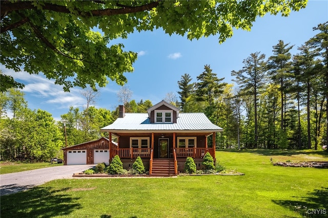 view of front facade featuring a porch, a garage, a front lawn, french doors, and an outdoor structure