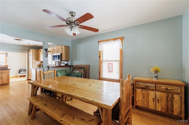 dining space featuring light hardwood / wood-style floors, heating unit, and ceiling fan