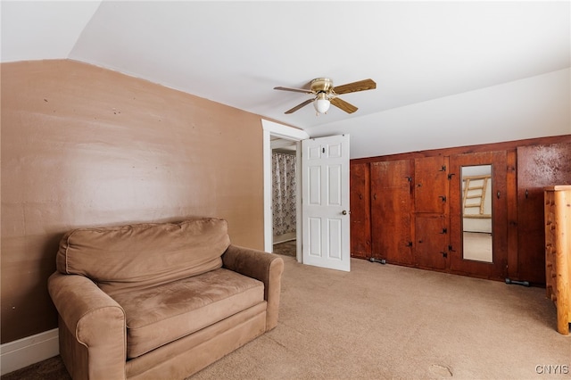 sitting room with vaulted ceiling, ceiling fan, and light colored carpet