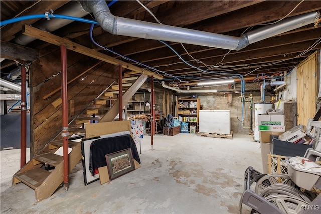 basement featuring gas water heater and fridge