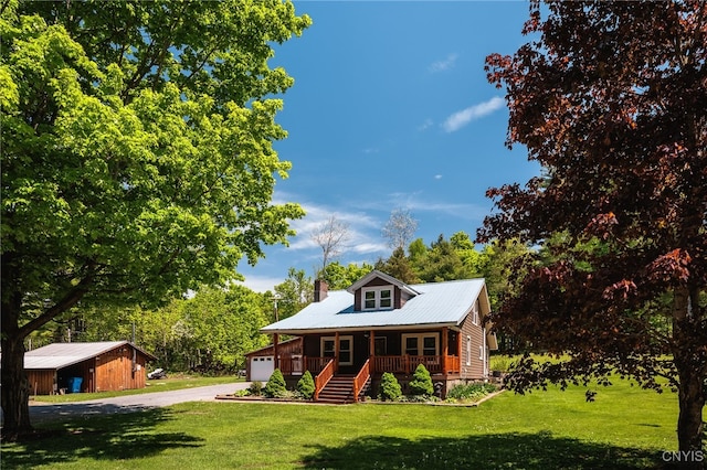 view of front of house with covered porch, a front yard, and a garage