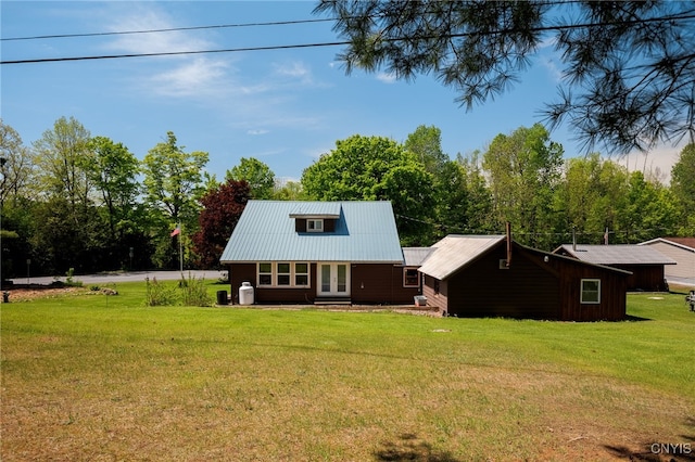 rear view of house with french doors and a lawn