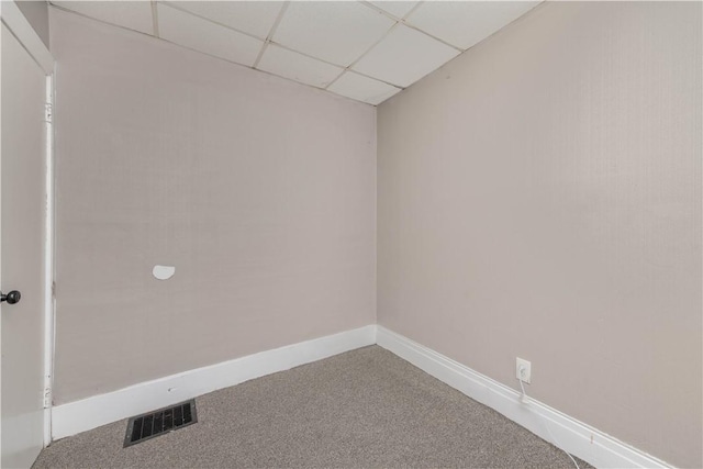 carpeted spare room featuring a paneled ceiling