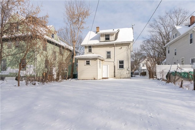 snow covered rear of property with an outbuilding