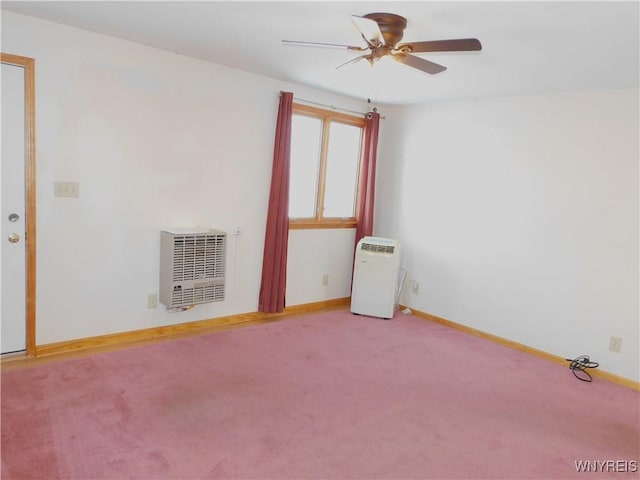 unfurnished room with ceiling fan, heating unit, and carpet floors