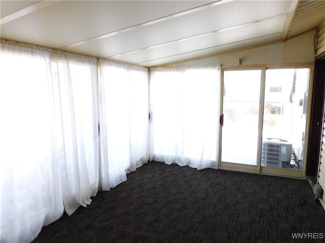 unfurnished sunroom featuring lofted ceiling with beams