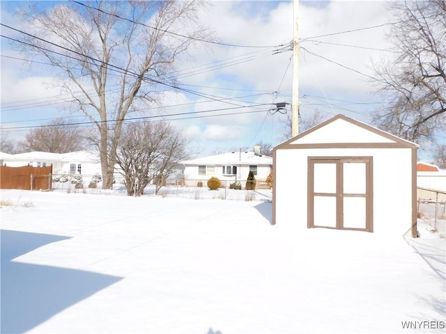 snowy yard with a shed