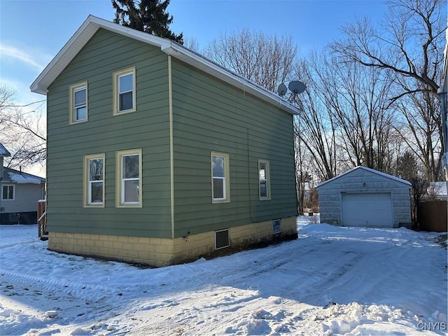 view of snow covered exterior with a garage and an outdoor structure