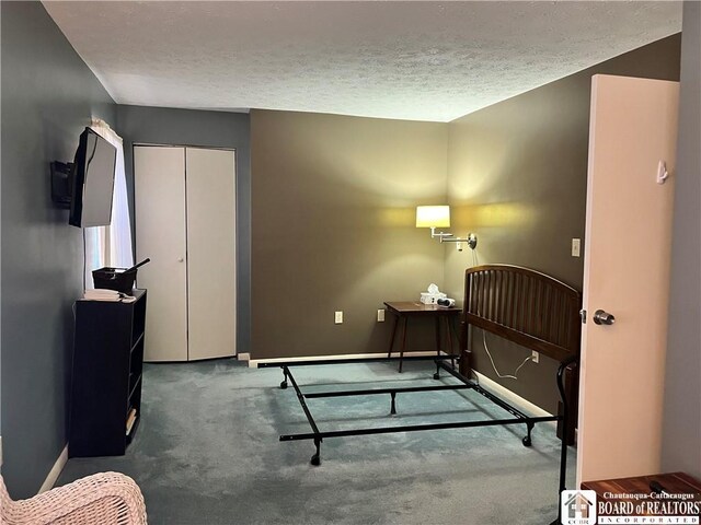 bedroom featuring dark colored carpet, a textured ceiling, and a closet