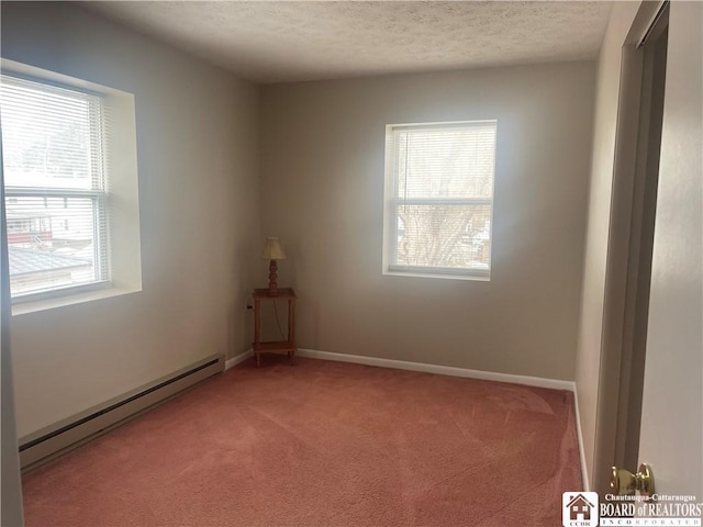 spare room with baseboards, a baseboard heating unit, a textured ceiling, and light colored carpet