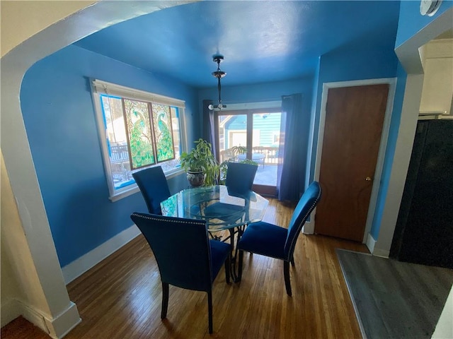 dining area with a notable chandelier and hardwood / wood-style flooring