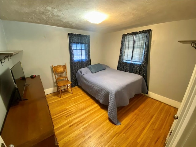 bedroom with wood-type flooring and a textured ceiling