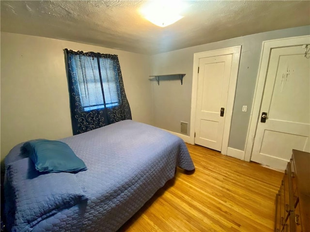 bedroom featuring a textured ceiling and light wood-type flooring