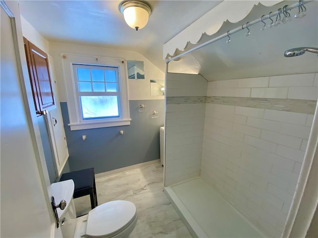 bathroom with toilet and a tile shower