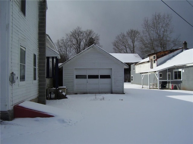 view of snow covered exterior featuring an outdoor structure and a garage