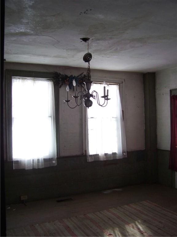 unfurnished dining area featuring a notable chandelier