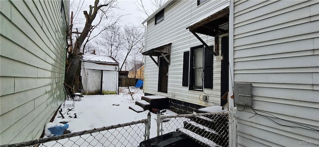 view of snow covered exterior featuring a shed