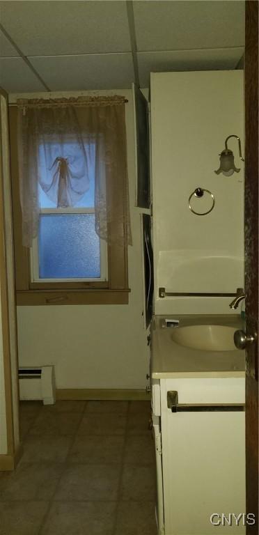 clothes washing area with sink and a baseboard heating unit