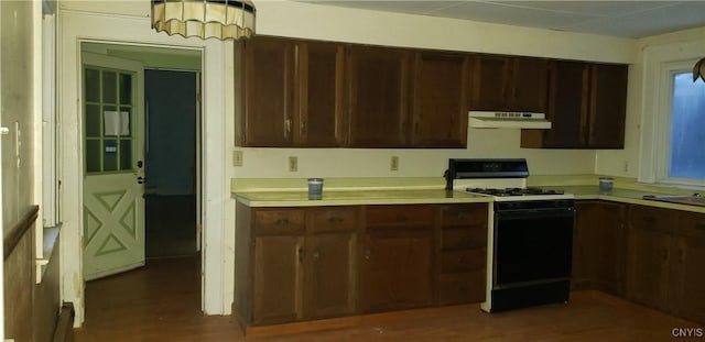 kitchen featuring dark brown cabinetry, dark hardwood / wood-style floors, and gas stove