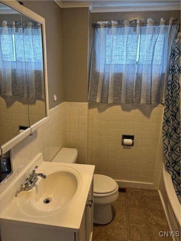 full bathroom with tile patterned flooring, tile walls, toilet, vanity, and shower / bath combo with shower curtain