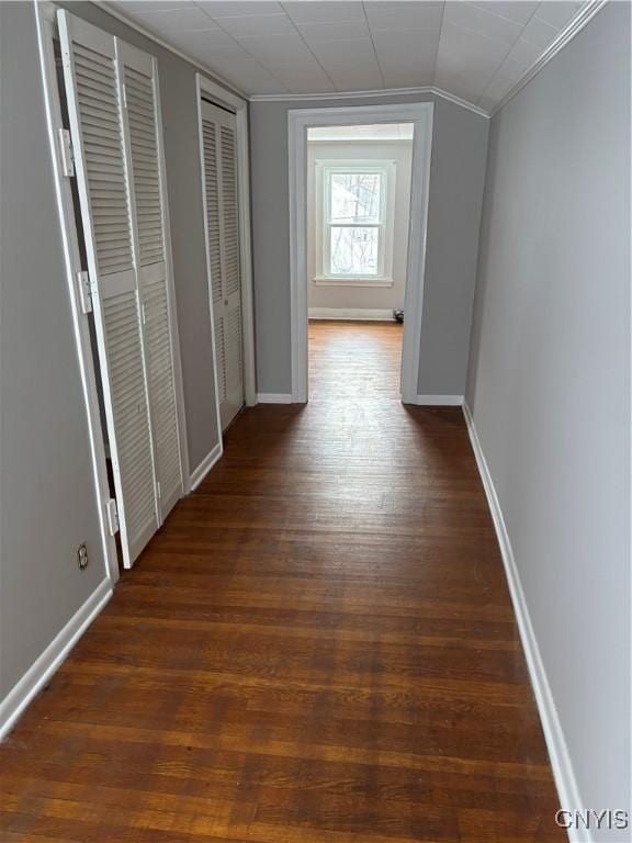 hall with dark wood-type flooring and vaulted ceiling