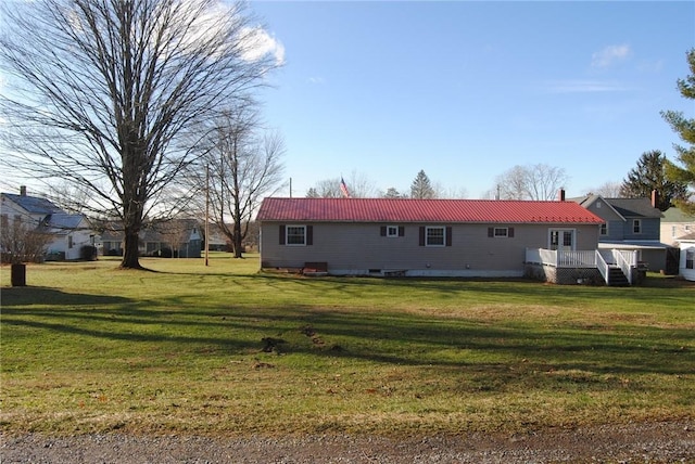 rear view of house featuring a yard