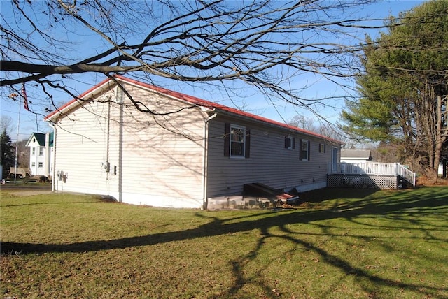 view of property exterior featuring a wooden deck and a yard