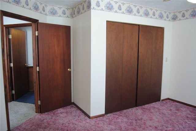 unfurnished bedroom featuring light colored carpet and a closet