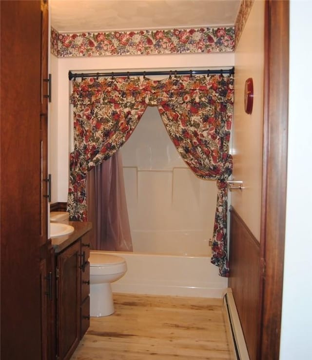 full bathroom with a baseboard radiator, wood-type flooring, vanity, shower / tub combo, and toilet