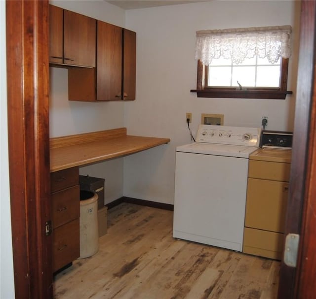 laundry room featuring cabinets, light hardwood / wood-style flooring, and washing machine and clothes dryer