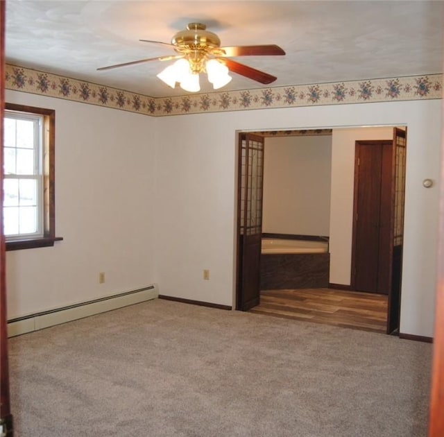 carpeted spare room featuring a baseboard radiator and ceiling fan